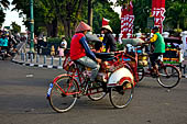 Riding the becak, the local cycle rickshaws in Malioboro street Yogyakarta. 